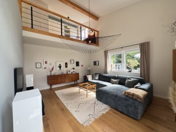 #IMMOTIONAL - MODERNES WOHNEN MIT PRIVATSPHÄRE UND BESONDERER ARCHITEKTUR - Wohnzimmer mit Blick zur Galerie